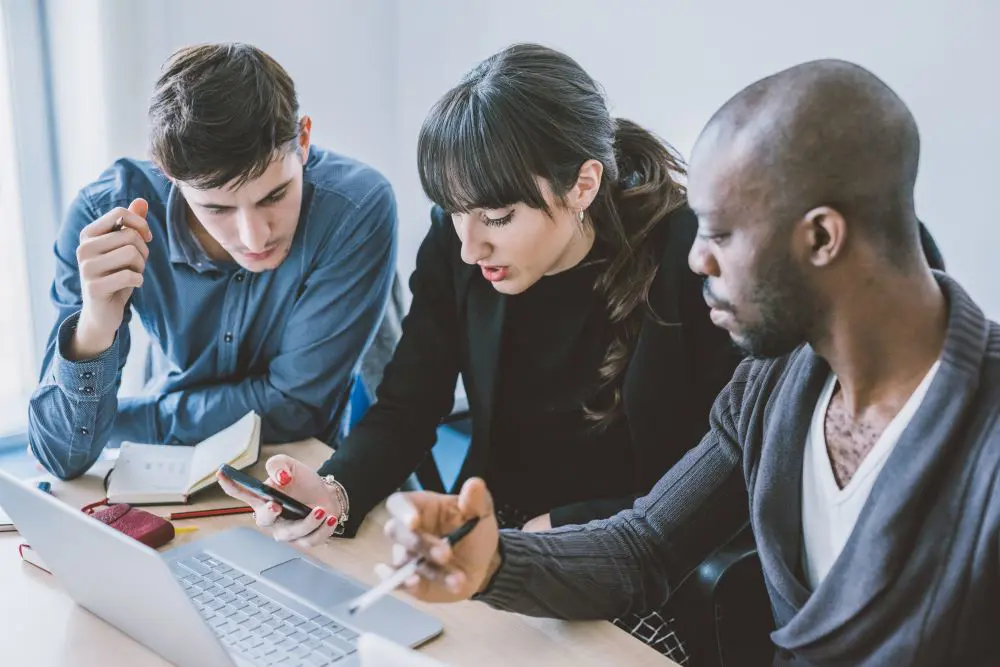 IT-Team mit Laptop und Smartphone