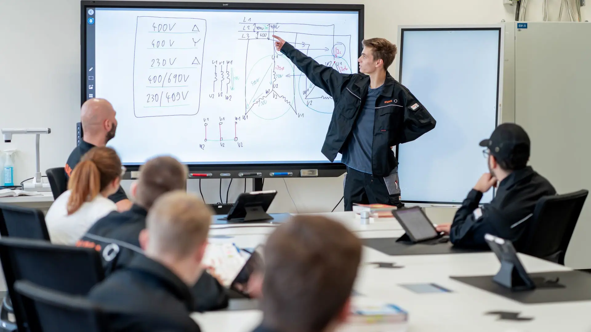 Viele Unternehmen fördern Nachwuchskräfte in ihrer Weiterentwicklung - hier: junger Techniker vor einem Monitor in einer KUKA-Schulungsveranstaltung.