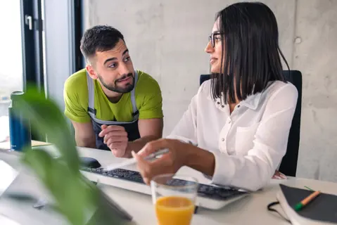 Männlicher und weiblicher Azubi bei Desktop-Arbeiten am Schreibtisch