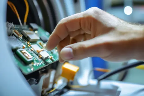 Ein Techniker arbeitet am Heizelement und Sensor einer Waschmaschine.